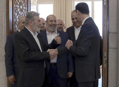 In this photo released by the Syrian official news agency SANA, Syrian President Bashar Assad, right, shakes hands with Ziad Nakhaleh, leader of the Palestinian Islamic Jihad group, as Khalil al-Hayeh, a senior figure in Hamas' political branch, center, and others wait to greet the president, in Damascus, Syria, Wednesday, Oct. 19, 2022. AP