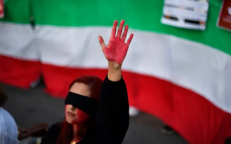 A woman raises her hand with red paint during a demonstration in support of Iranian women on Oct. 4, 2022, in Barcelona following the death of Kurdish Iranian woman Mahsa Amini in Iran. AFP