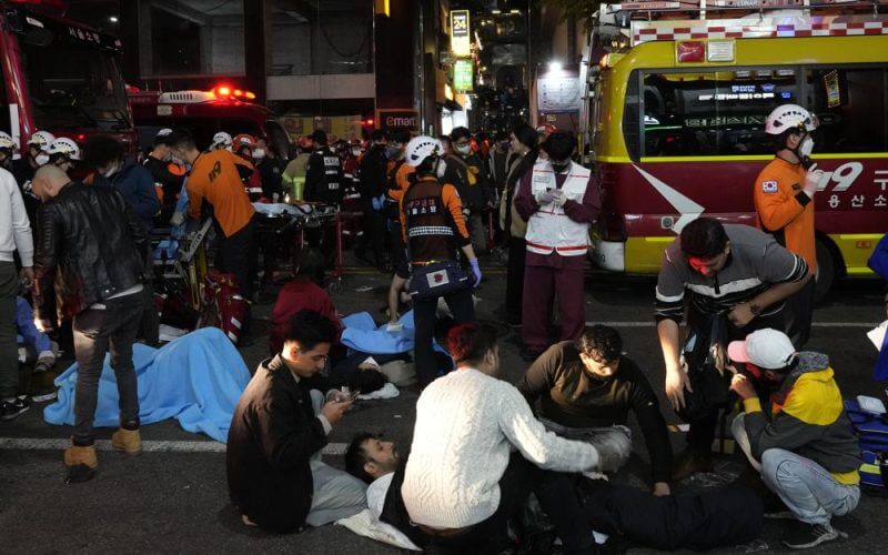 Rescue workers and firefighters try to help injured people near the scene of a crowd surge in Seoul, South Korea, Sunday, Oct. 30, 2022. AP