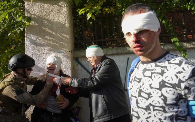 People receive medical treatment at the scene of Russian shelling, in Kyiv, Ukraine, Monday, Oct. 10, 2022. AP