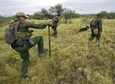 U.S. Border Patrol agents, aided by a dog and a Black Hawk helicopter, search for a group of migrants evading capture at the base of the Baboquivari Mountains on Sept. 8, 2022, near Sasabe, Ariz. The desert region located in the Tucson sector just north of Mexico is one of the deadliest stretches along the international border with rugged desert mountains, uneven topography, washes and triple-digit temperatures in the summer months. Border Patrol agents performed 3,000 rescues in the sector in the past 12 months. Matt York / AP Photo