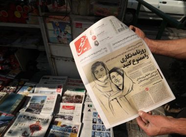 A man holds a copy of the Ham-Mihan newspaper in the Iranian capital, Tehran, Oct. 30, 2022. The newspaper features a story on the detention of journalists Niloufar Hamedi and Elaheh Mohammadi who, according to local media, helped publicize the case of Masha Amini. AFP