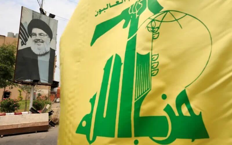 A Hezbollah flag and a poster depicting Lebanon's Hezbollah leader Sayyed Hassan Nasrallah are pictured along a street, near Sidon, Lebanon July 7, 2020. Reuters