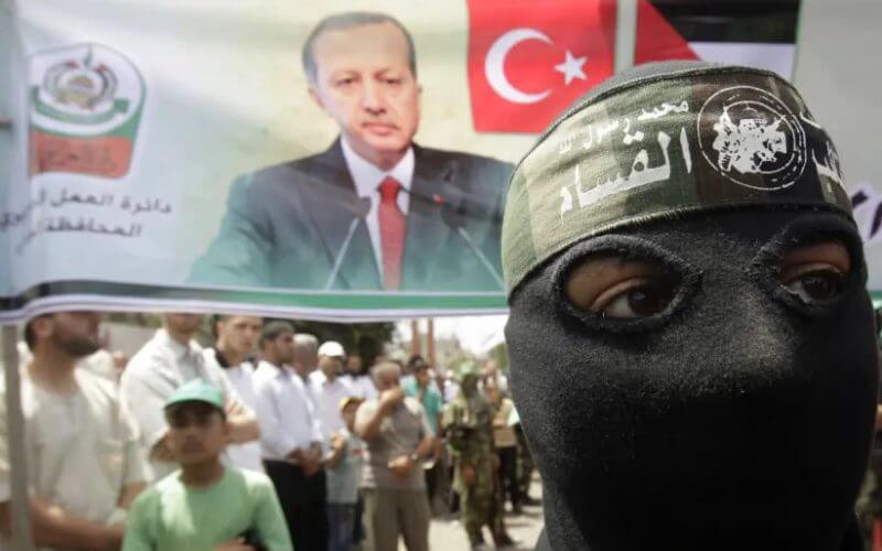 A masked member of Hamas stands in front of a banner depicting Turkey’s Prime Minister Tayyip Erdogan during a protest in Central Gaza Strip June 4, 2010 (photo credit: REUTERS/IBRAHEEM ABU MUSTAFA)