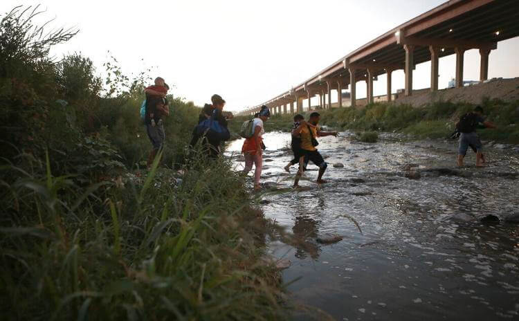 Venezuelan migrants walk across the Rio Bravo towards the United States border to surrender to the border patrol, from Ciudad Juarez, Mexico, Oct. 13, 2022. A surge in migration from Venezuela, Cuba and Nicaragua in September brought the number of illegal crossings to the highest level ever recorded in a fiscal year, according to U.S. Customs and Border Protection. Christian Chavez