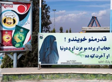 This photograph taken on November 9, 2022, shows a poster (R) reading in Pashto, “Dear sisters! Hijab and veil are your dignity and are in your benefit in this world and in the hereafter”, at the Habibullah Zazai Park on the outskirts of Kabul. (Photo by WAKIL KOHSAR/AFP via Getty Images)