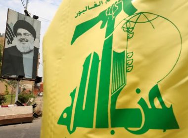 A Hezbollah flag and a poster depicting Lebanon's Hezbollah leader Sayyed Hassan Nasrallah are pictured along a street, near Sidon, Lebanon July 7, 2020. (photo credit: REUTERS/ALI HASHISHO)