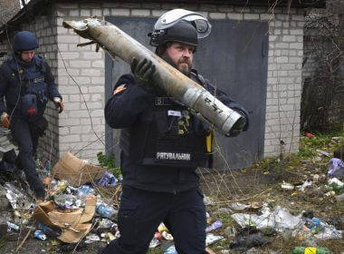 A Ukrainian sapper carries a part of a projectile during a demining operation in a residential area in Lyman, Donetsk region, Ukraine, Wednesday, Nov. 16, 2022. (AP Photo/Andriy Andriyenko)