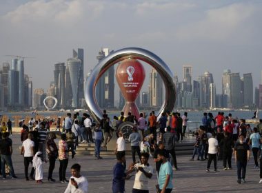 People gather around the official countdown clock showing remaining time until the kick-off of the World Cup 2022, in Doha, Qatar, Friday, Nov. 11, 2022. AP