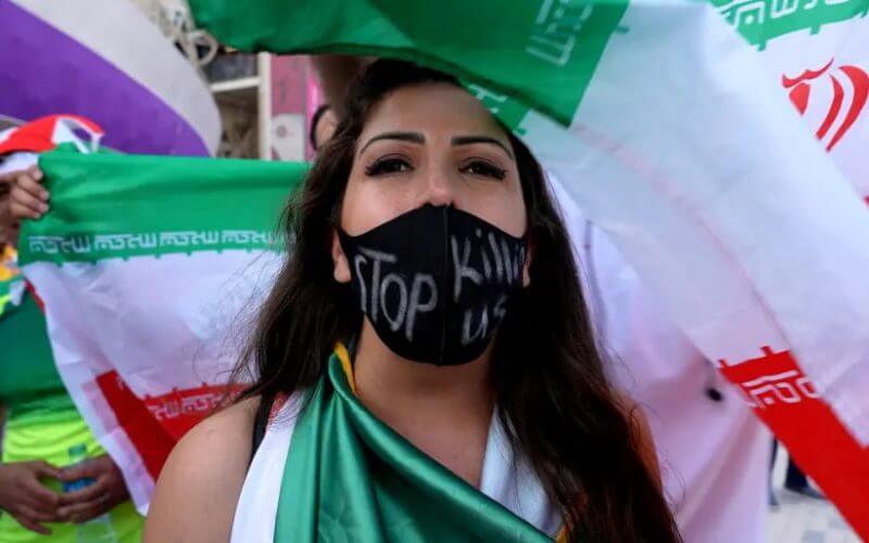 A woman wearing a facemask with a message reading 'stop killing us' after the Wales v Iran match. (photo credit: REUTERS/CHARLOTTE BRUNEAU)