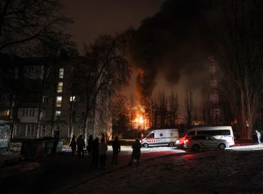 Residents gather as a critical power infrastructure facility burns after a Russian drone attack in Kyiv on Monday. (Gleb Garanich/Reuters)