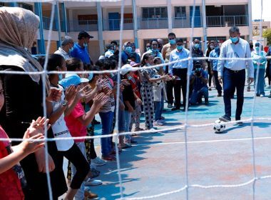 Philippe Lazzarini (R), commissioner-general of UNRWA, plays with a soccer ball in front of students in Gaza's Shati refugee camp. AP