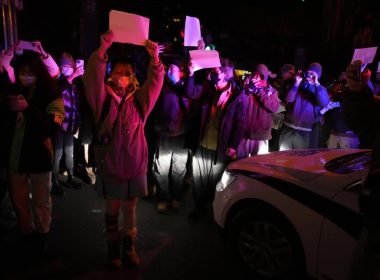 Protesters hold up blank papers and chant slogans as they march in protest in Beijing, Sunday, Nov. 27, 2022. AP