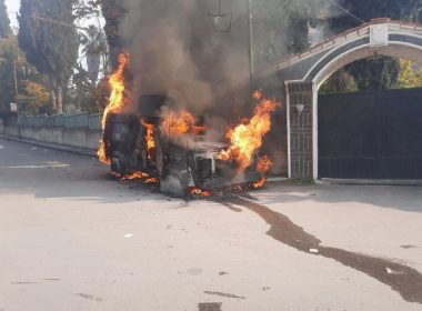 A police vehicle burns as Syrians take part in an anti-government protest in Sweida [Suwayda 24/via Reuters]