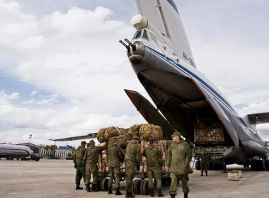 Russian air force personnel prepare to load cargo on board a Syrian Il-76 plane at Hemeimeem air base in Syria. AP