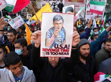 A man holds up an anti-U.S. placard during an annual demonstration in front of the former U.S. Embassy in Tehran, Iran. AP