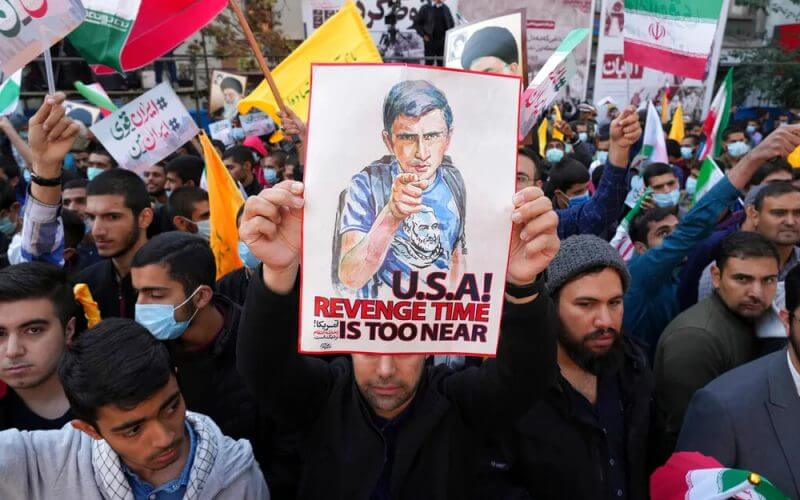 A man holds up an anti-U.S. placard during an annual demonstration in front of the former U.S. Embassy in Tehran, Iran. AP