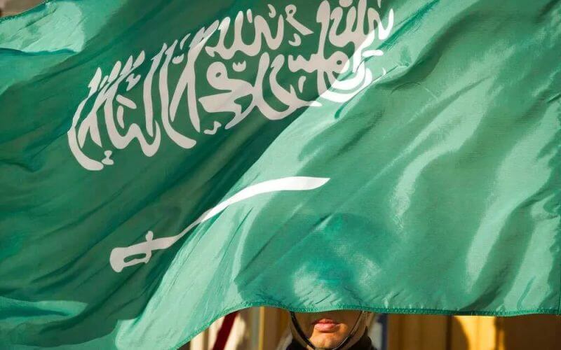 An honor guard member is covered by the flag of Saudi Arabia in Washington, the United States. AP