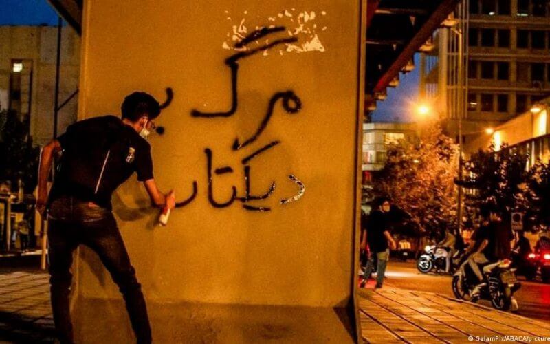 An Iranian protester writes "Death to the dictator!" on a wall in Tehran. Image: SalamPix/ABACA/picture alliance