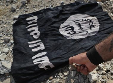 A fighter from the Christian Syriac militia that battles the Islamic State group under the banner of the US-backed Syrian Democratic Forces, burns an IS flag on the front line on the western side of Raqqa, northeast Syria, July 17, 2017. AP