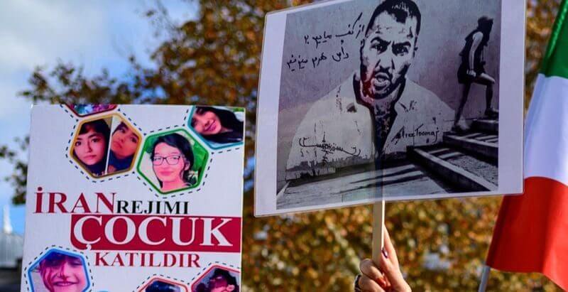 People hold placards bearing portraits of Iranian rapper Toomaj Salehi (Photo: Yasin Akgul/AFP/Getty Images)