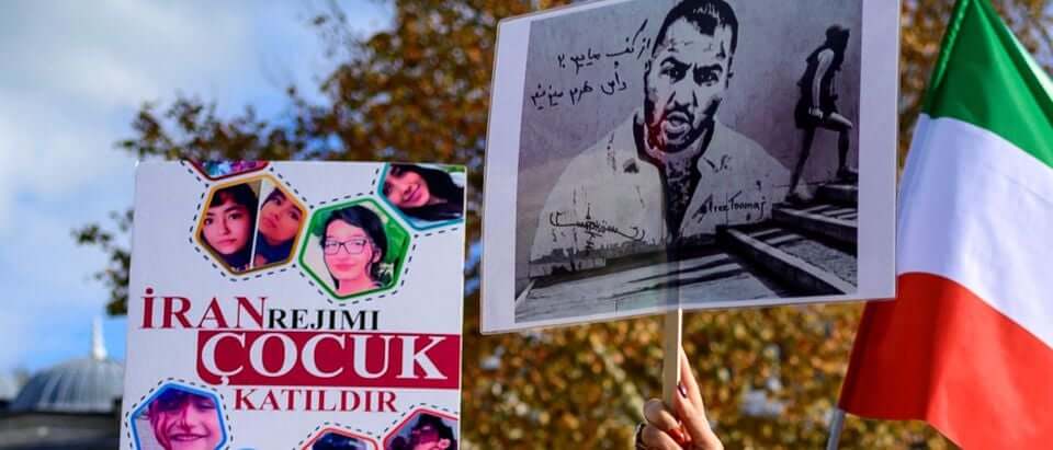 People hold placards bearing portraits of Iranian rapper Toomaj Salehi (Photo: Yasin Akgul/AFP/Getty Images)