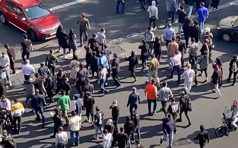 In this frame grab from a video, people are blocking an intersection during a protest to mark 40 days since the death in custody of 22-year-old Mahsa Amini, whose tragedy sparked Iran's biggest antigovernment movement in over a decade, in Tehran, Iran, Wednesday, Oct. 26, 2022. (AP Photo)
