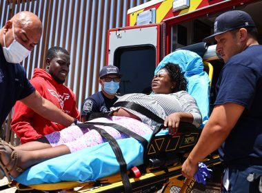 Paramedics load a pregnant migrant from Haiti into an ambulance May 21 in San Luis, Arizona. (Photo: Mario Tama/Getty Images)