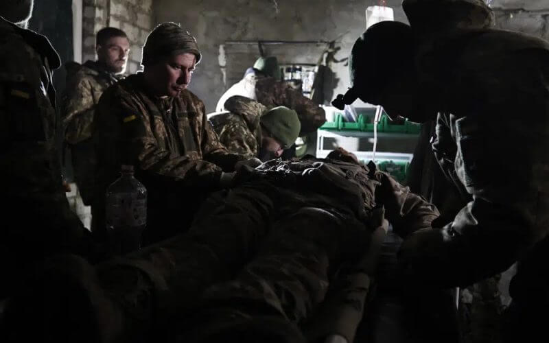 Ukrainian servicemen give the first aid to a soldier wounded in a battle with the Russian troops in their shelter in the Donetsk region, Ukraine, Thursday, Dec. 1, 2022.