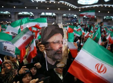 Supporters of hard-line cleric Ebrahim Raisi hold his photo and wave their country's flag in Tehran, Iran. AP