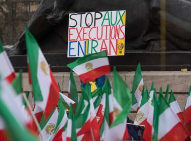 A demonstrator holds up a sign reading "Stop Executions in Iran" during a rally in France. AP