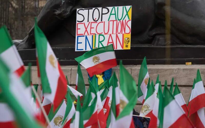 A demonstrator holds up a sign reading "Stop Executions in Iran" during a rally in France. AP