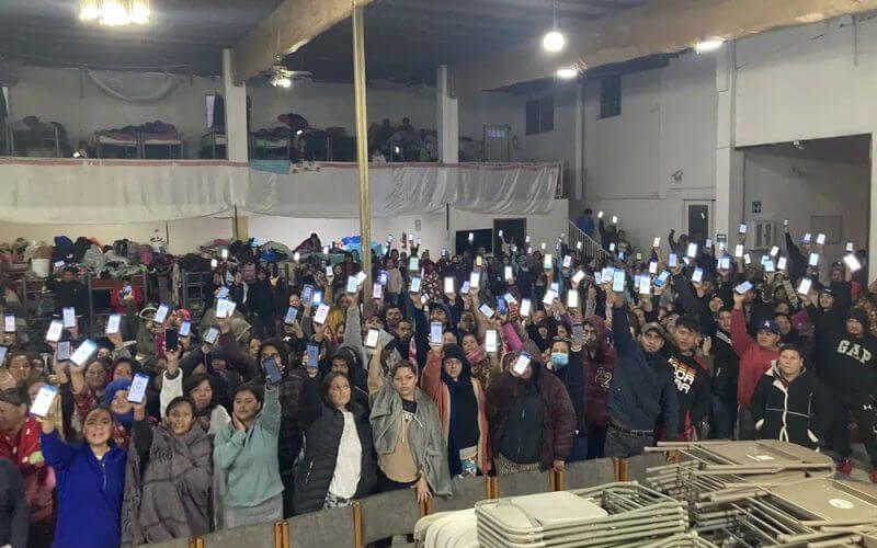 Migrants hold up their phones showing the CBPOne app at a shelter Sunday, Jan 22, 2023, in Tijuana, Mexico. AP