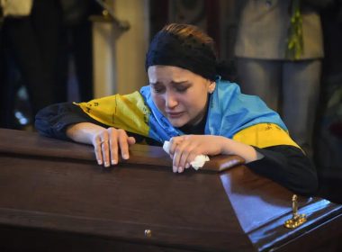 The widow cries at the coffin of volunteer soldier Oleksandr Makhov, 36 a well-known Ukrainian journalist, killed by the Russian troops, at St. Michael cathedral in Kyiv, Ukraine, Monday, May 9, 2022.