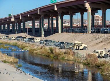 Texas National Guards line up their armored vehicles in the northern bank of the Rio Grande to prevent migrants from approaching the border fence near El Paso on Wednesday, Dec. 21, 2022. AP