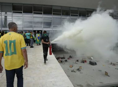 A protester, supporter of Brazil's former President Jair Bolsonaro, empties a fire extinguisher after protesters stormed Planalto Palace in Brasilia, Brazil, Sunday, Jan. 8, 2023. AP