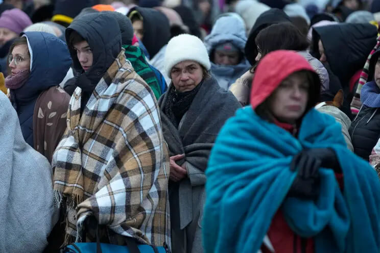 Refugees wait in a crowd for transportation after fleeing from Ukraine and arriving at the border crossing in Medyka, Poland, on March 7, 2022. AP