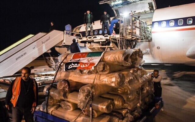 Workers unload aid from a plane sent by Iran, at the airport in Syria's northern city of Aleppo, early on February 8, 2023, following a deadly earthquake. (AFP)