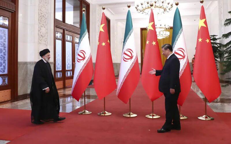 In this photo released by the official website of the office of the Iranian Presidency, President Ebrahim Raisi, left, arrives in an official welcoming ceremony by his Chinese counterpart Xi Jinping in Beijing, Tuesday, Feb. 14, 2023. (Iranian Presidency Office via AP)