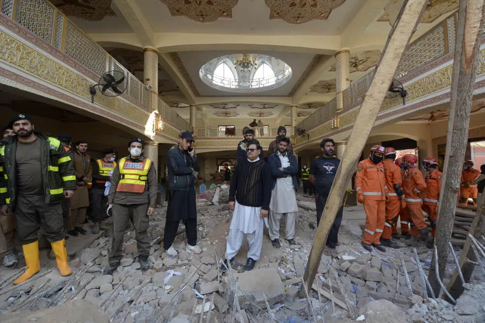 Rescue workers gather as they conduct an operation to clear the rubble and search for bodies at the site of Monday's suicide bombing, in Peshawar, Pakistan, Tuesday, Jan. 31, 2023. AP