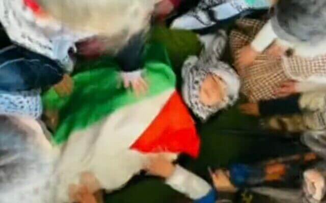 Screen capture from a video published by the Al-Tofula Kindergarten in Beit Awwa in the West Bank, showing children simulating a ‘martyr’ funeral for one of their number who is killed in a pretend clash with the IDF, February 14, 2023. Twitter
