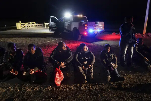 Migrants wait to be processed after crossing the border on Jan. 6, 2023, near Yuma, Ariz. AP