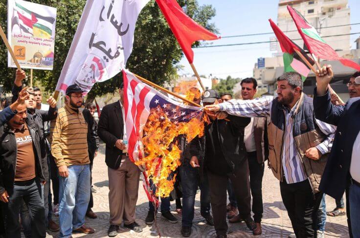 Palestinian protesters burn the US flag during a demonstration organized by the Popular Front for the Liberation of Palestine. / Getty Images