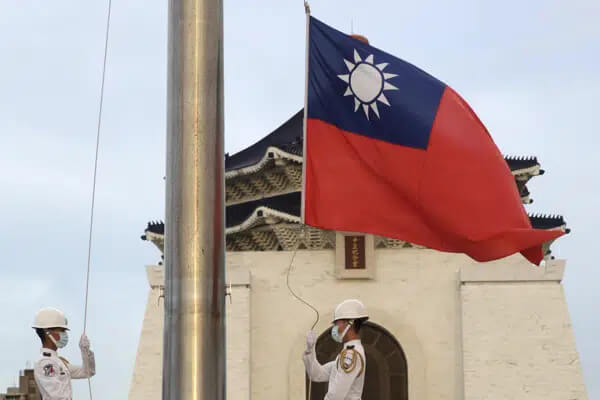 Two soldiers lower the national flag during the daily flag ceremony on Liberty Square of the Chiang Kai-shek Memorial Hall in Taipei, Taiwan, July 30, 2022.