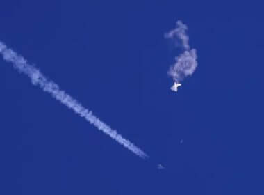A fighter jet flies past the remnants of a large balloon after it was shot down above the Atlantic Ocean, just off the coast of South Carolina near Myrtle Beach, Feb. 4, 2023. AP