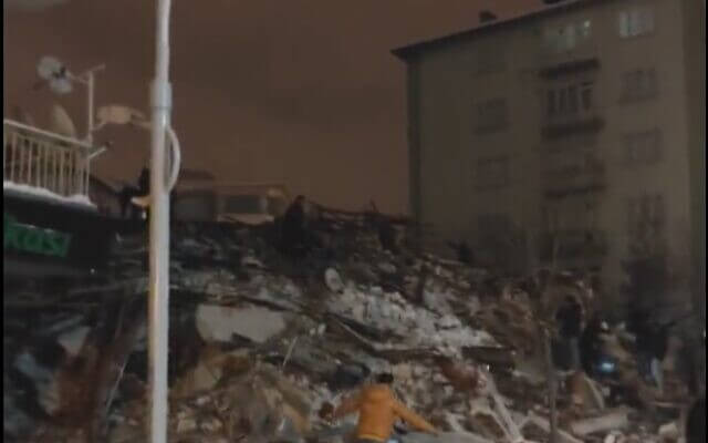 People look through rubble of a collapsed building in Trueky following an earthquake on February 6, 2023. (screen capture: Twitter)