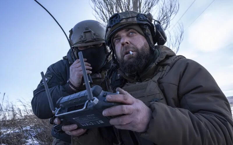 A Ukrainian serviceman aka Zakhar, right and commander of a unit aka Kurt, look on a screen of a drone remote control during fighting, at the frontline in Donetsk region, Ukraine, Monday, Feb. 13, 2023. (AP Photo/Evgeniy Maloletka)