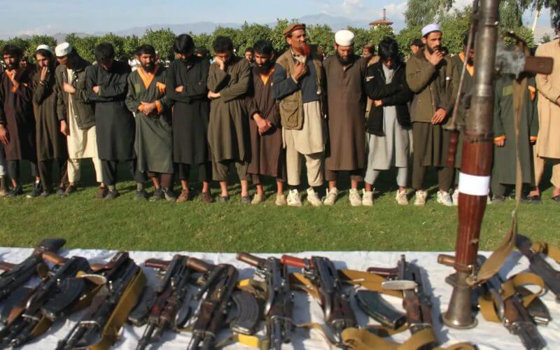 Members of ISIS-K stand in front of their weapons as they surrendered to the government in Jalalabad, Nangarhar, Afghanistan on November 17, 2019. Wali Sabawoon/Getty Images