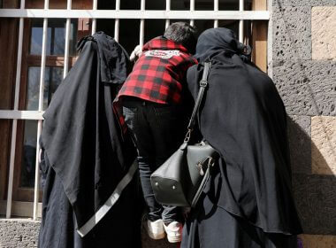 Women and a boy wait for a foodstuff assistance vouchers at an aid distribution center in Sanaa, Yemen January 25, 2021. Picture taken January 25, 2021. REUTERS/Khaled Abdullah