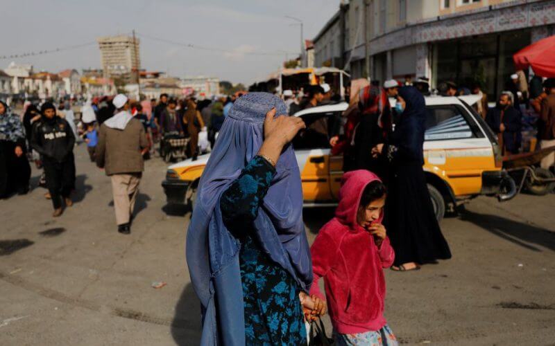 An Afghan woman and a girl walk in a street in Kabul, Afghanistan, November 9, 2022. REUTERS/Ali Khara
